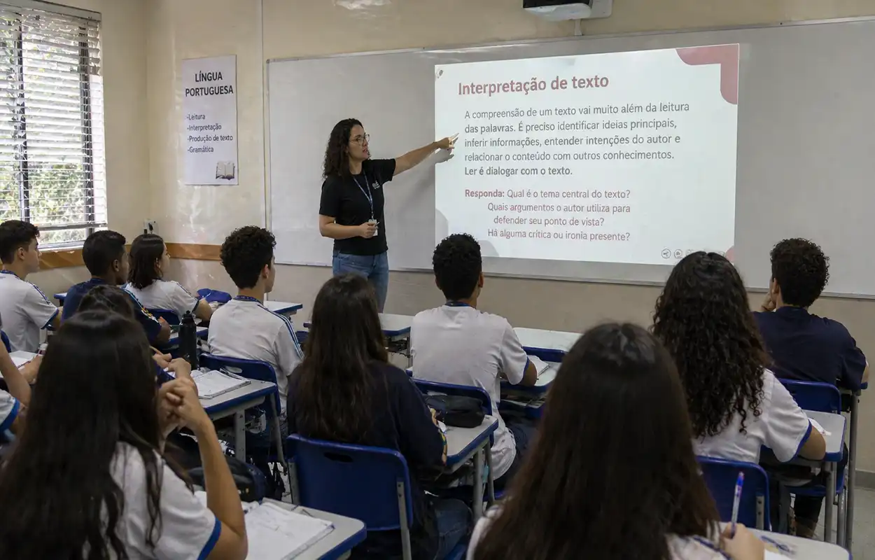 professor de português ensinando interpretação de texto em sala de aula com projetor e alunos atentos